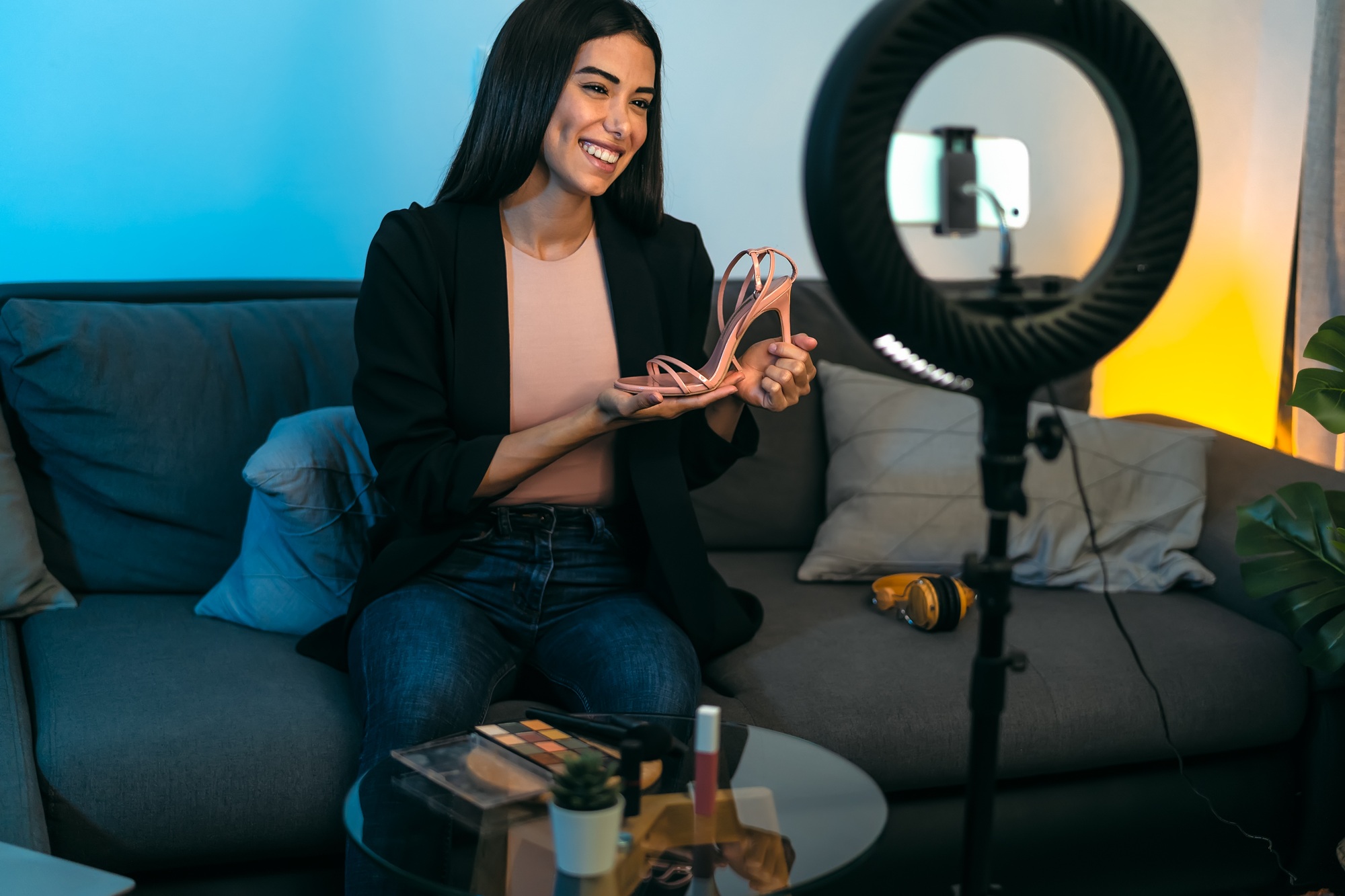 Female influencer vlogging online with smartphone cam and ring led from home