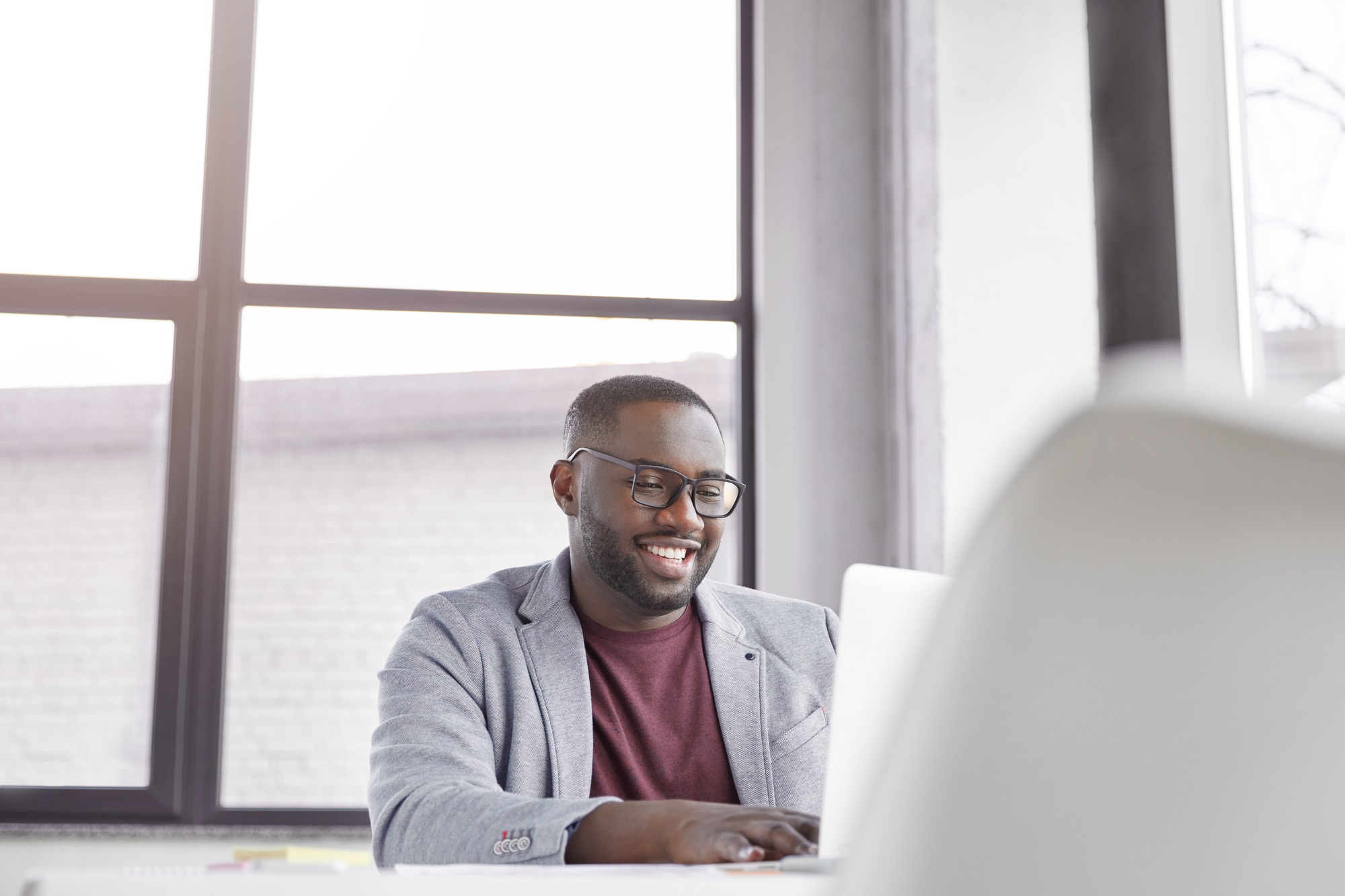 Glad black man manager keyboards on laptop computer, searches information about marketing agency. Po